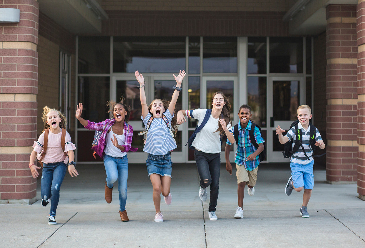 Group of middle school students cheering as they leave school