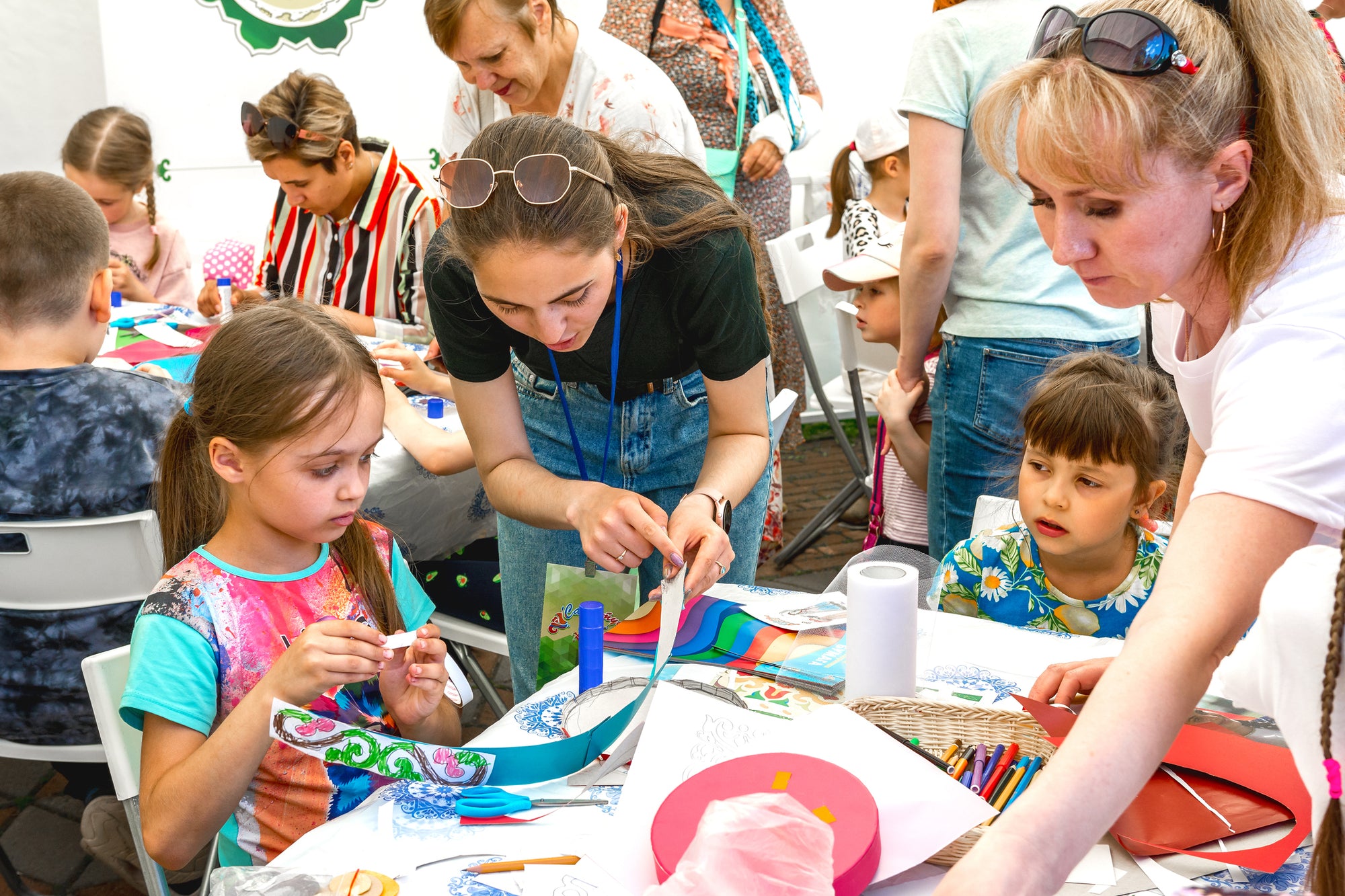 kids and parents in a classroom working on an arts and crafts project