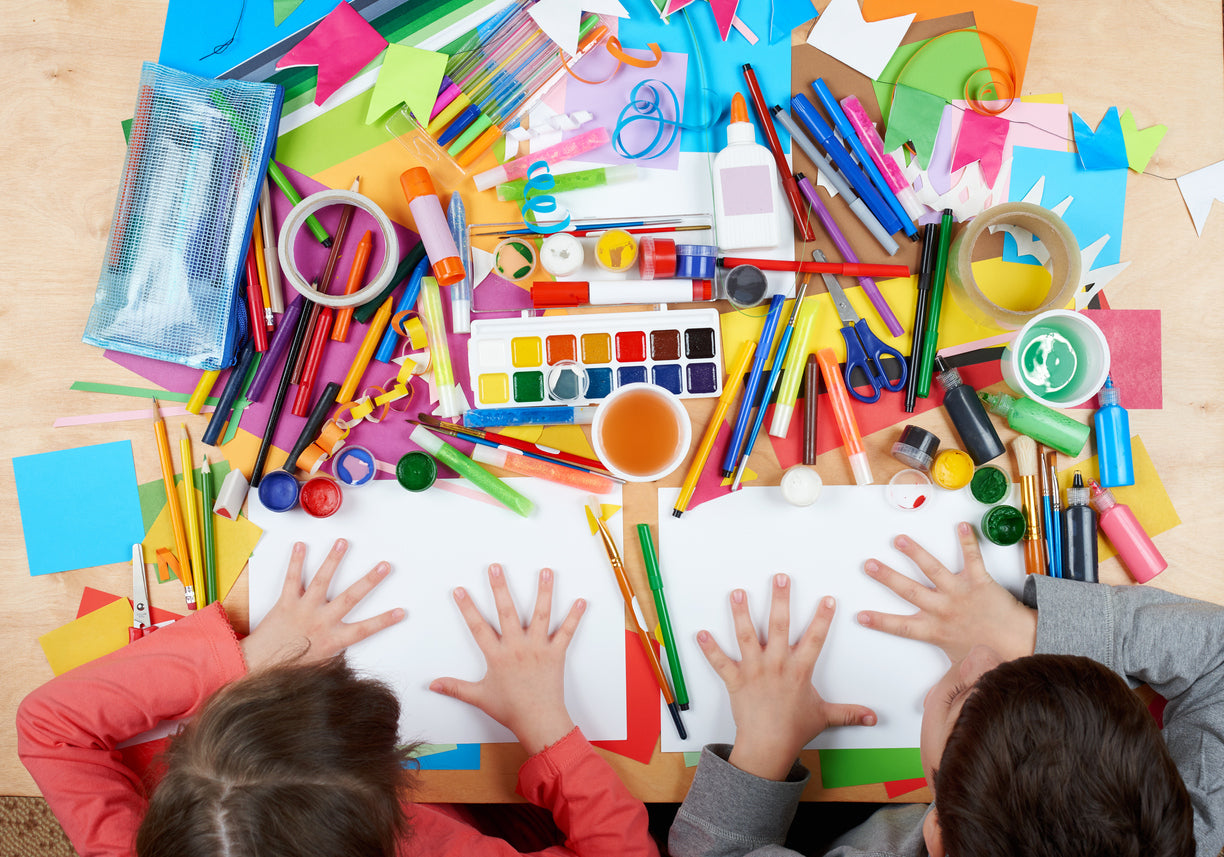 students students at a desk full of colorful classroom supplies