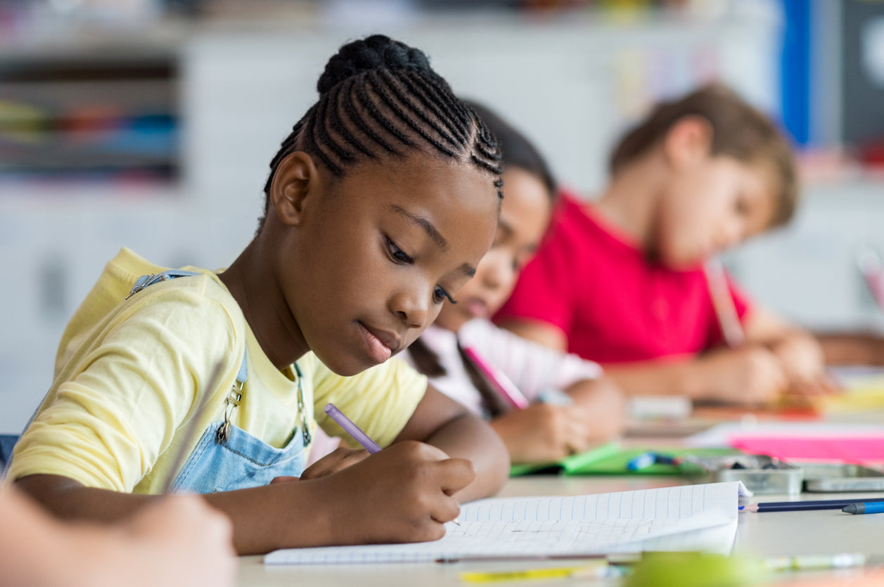 elementary school students writing in their notebooks